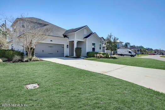 view of front of home with a garage, a front lawn, and driveway