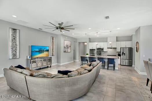 living room with recessed lighting, baseboards, and visible vents