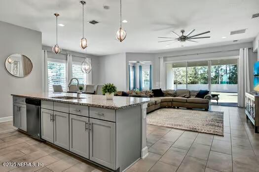 kitchen with a wealth of natural light, a ceiling fan, gray cabinets, a sink, and dishwasher