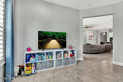 rec room featuring a ceiling fan and baseboards