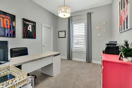 office space with baseboards and light carpet