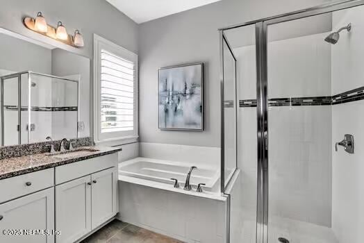 bathroom with vanity, a bath, and a stall shower