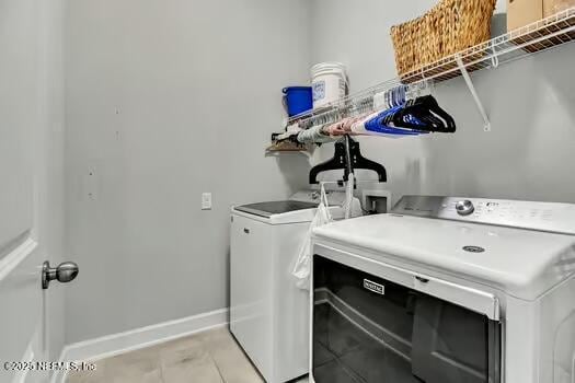 laundry area featuring light tile patterned floors, laundry area, independent washer and dryer, and baseboards