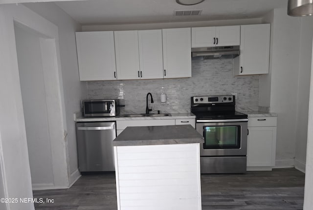 kitchen featuring visible vents, appliances with stainless steel finishes, white cabinets, a sink, and under cabinet range hood