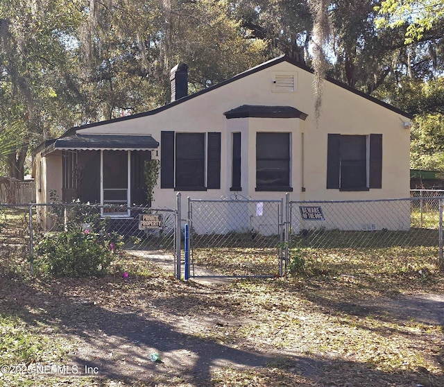 manufactured / mobile home with a fenced front yard, a chimney, stucco siding, crawl space, and a gate