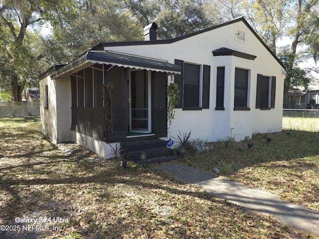 view of front facade featuring fence and stucco siding