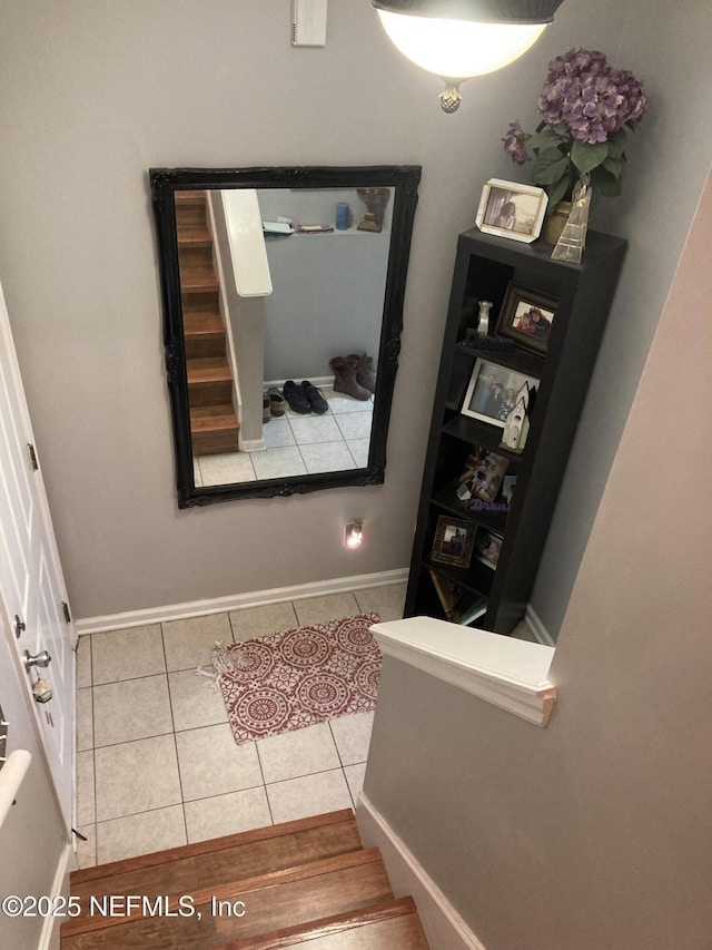 interior space with stairway, baseboards, and tile patterned flooring