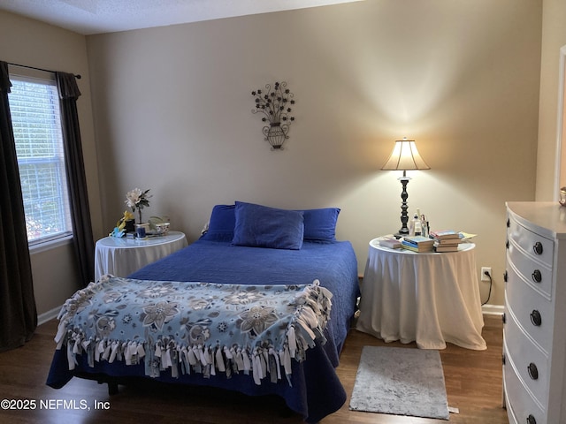 bedroom with wood finished floors and baseboards