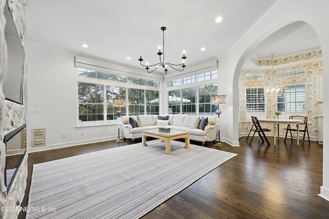 sunroom / solarium featuring a notable chandelier and arched walkways