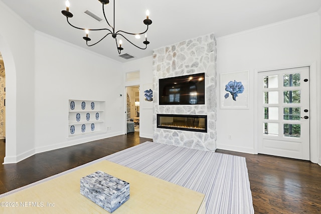 living room featuring a fireplace, crown molding, wood finished floors, and arched walkways