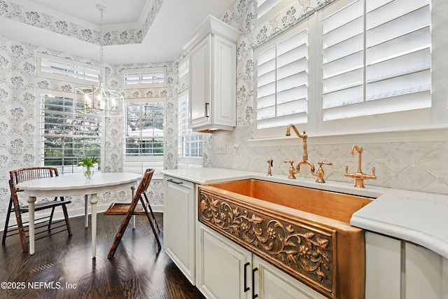 kitchen featuring wallpapered walls, dark wood-type flooring, light countertops, white cabinetry, and a raised ceiling