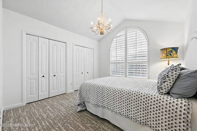 bedroom featuring a notable chandelier, two closets, carpet, baseboards, and vaulted ceiling