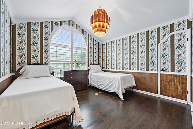 bedroom featuring wood finished floors, crown molding, wallpapered walls, baseboards, and vaulted ceiling