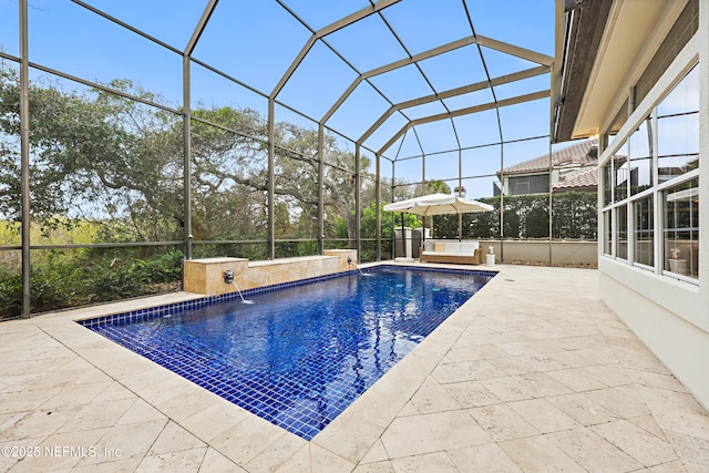 pool featuring glass enclosure and a patio area