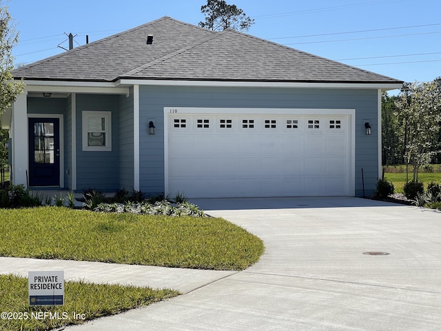 view of front of property with a garage, driveway, and roof with shingles