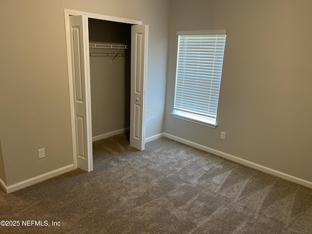 unfurnished bedroom featuring a closet, baseboards, and carpet flooring