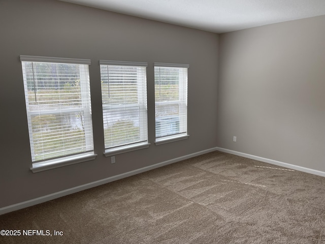 unfurnished room featuring baseboards and carpet