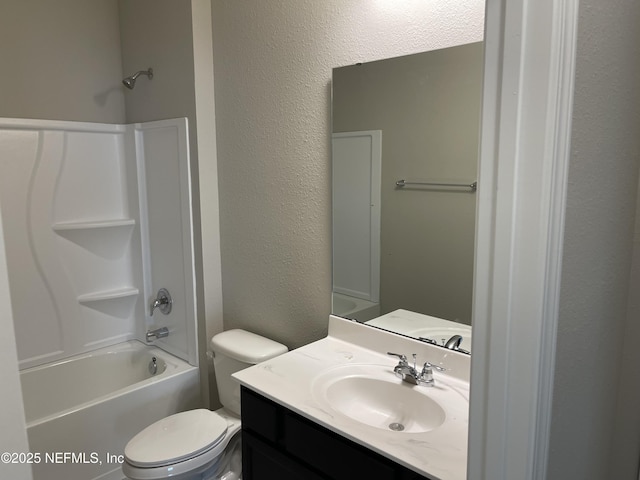 bathroom featuring toilet, vanity, shower / bathing tub combination, and a textured wall