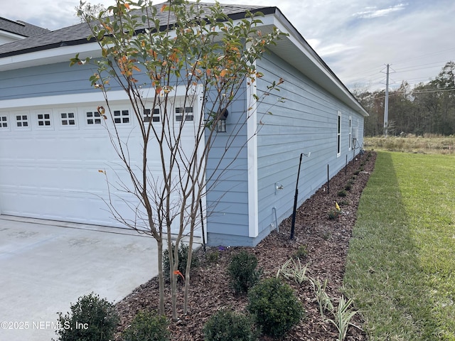 view of side of property featuring a yard and a garage