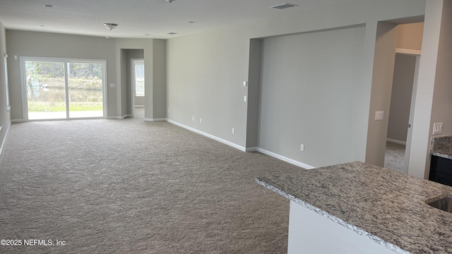 living area featuring carpet flooring, visible vents, and baseboards