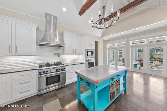 kitchen with beamed ceiling, french doors, stainless steel appliances, white cabinetry, and wall chimney exhaust hood