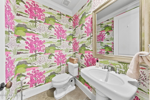 bathroom with visible vents, toilet, ornamental molding, a sink, and wallpapered walls