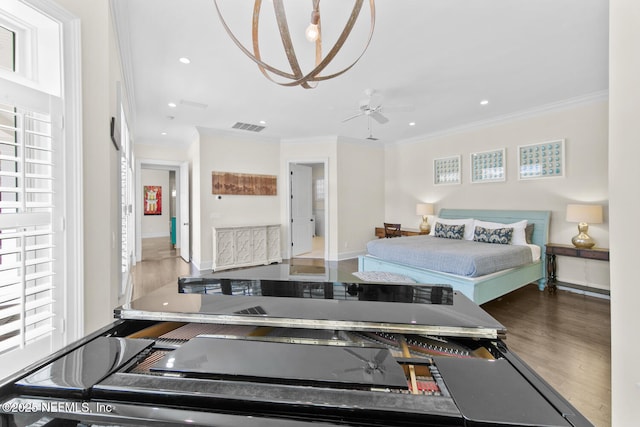 bedroom with recessed lighting, wood finished floors, visible vents, and ornamental molding