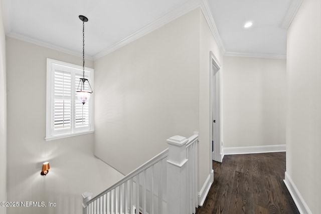 hall with baseboards, dark wood finished floors, ornamental molding, an upstairs landing, and recessed lighting