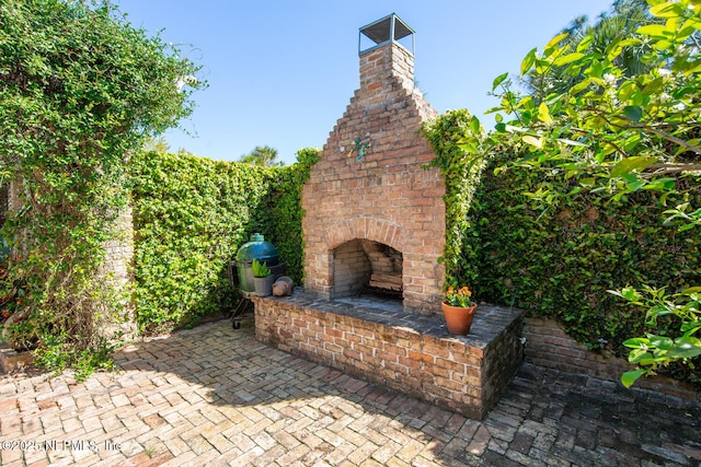 view of patio featuring an outdoor brick fireplace