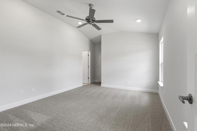 empty room with baseboards, visible vents, lofted ceiling, ceiling fan, and carpet