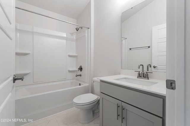 bathroom featuring toilet, marble finish floor, a textured ceiling, vanity, and washtub / shower combination