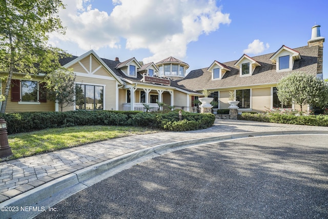 view of front of property with a shingled roof and a chimney