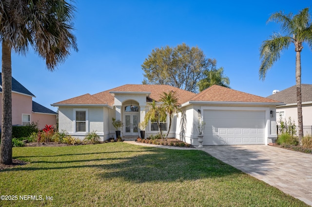 view of front facade with a front yard, driveway, an attached garage, stucco siding, and french doors