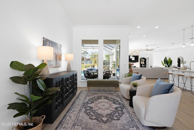 living room with recessed lighting, ornamental molding, ceiling fan, and wood finished floors