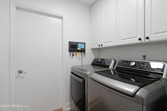 laundry room with washer and clothes dryer and cabinet space