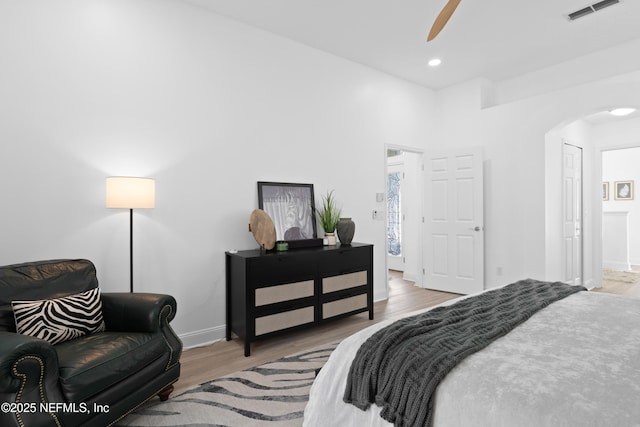 bedroom with visible vents, wood finished floors, recessed lighting, arched walkways, and baseboards