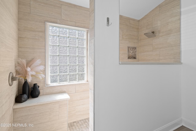 bathroom featuring vaulted ceiling and a walk in shower