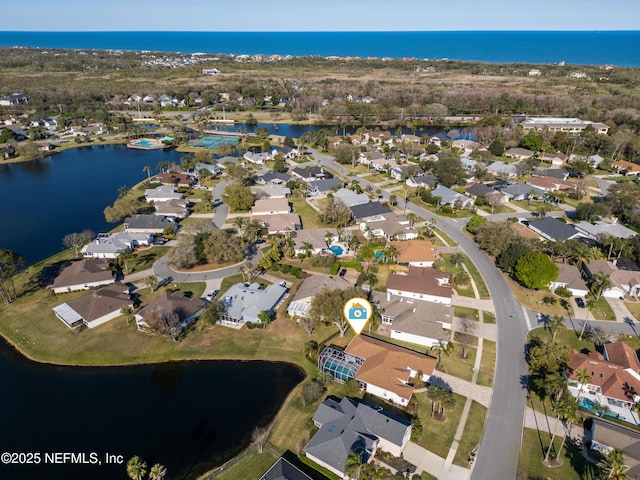 drone / aerial view featuring a residential view and a water view