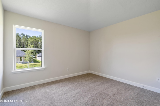 spare room featuring carpet floors and baseboards