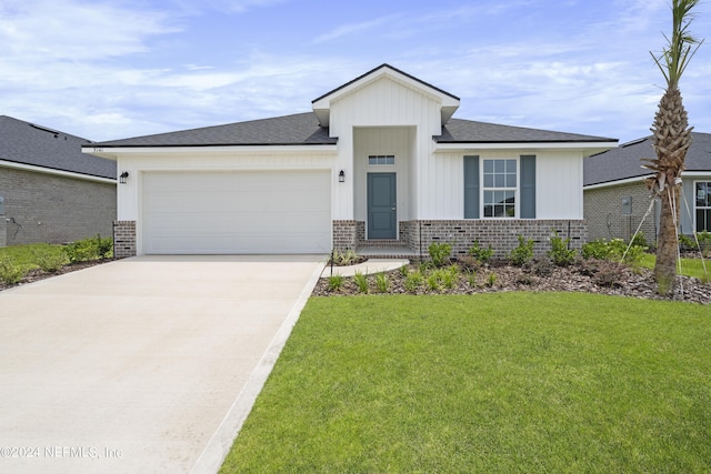 view of front of home with a garage, a front yard, brick siding, and driveway