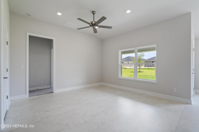 empty room featuring recessed lighting, marble finish floor, and baseboards