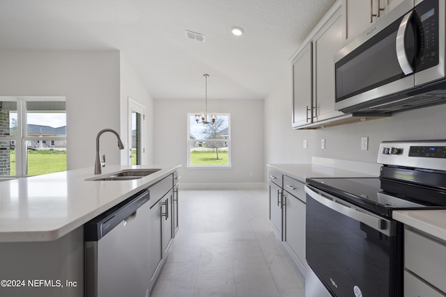 kitchen with stainless steel appliances, light countertops, visible vents, a sink, and a chandelier