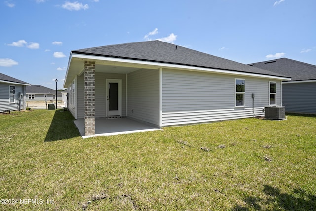 back of house featuring a yard, a patio, cooling unit, and roof with shingles