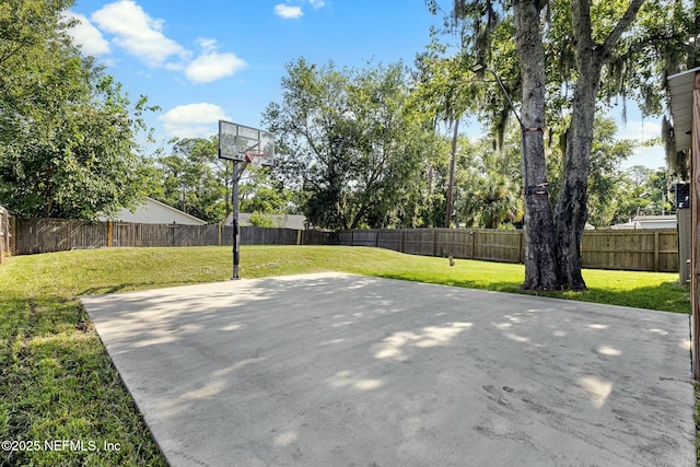 view of basketball court with a yard, basketball court, and a fenced backyard