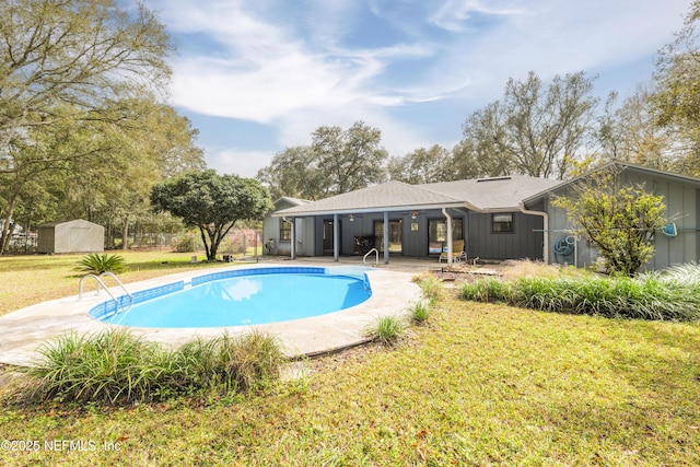 pool featuring a yard, a patio, a storage shed, and an outdoor structure