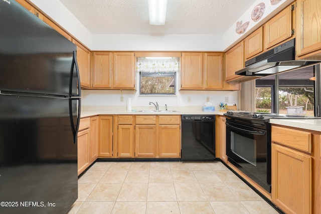 kitchen featuring black appliances, a sink, under cabinet range hood, light countertops, and light tile patterned floors