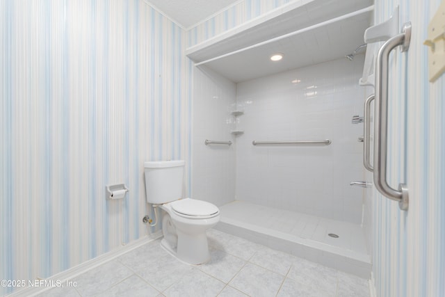 bathroom featuring wallpapered walls, tile patterned floors, toilet, and tiled shower