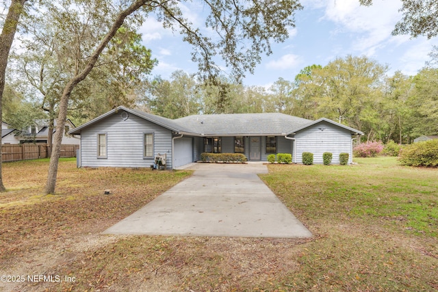 single story home with concrete driveway, fence, a garage, and a front yard