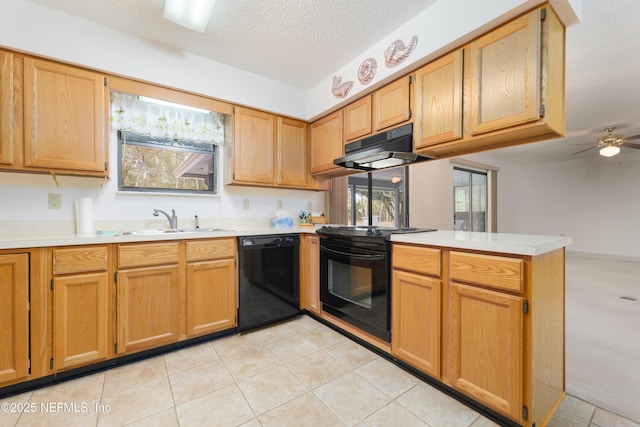 kitchen with a peninsula, a sink, black appliances, light countertops, and under cabinet range hood