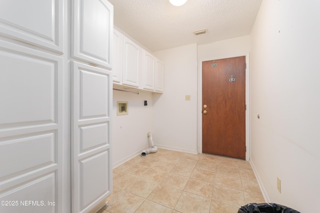 clothes washing area with visible vents, washer hookup, a textured ceiling, cabinet space, and light tile patterned floors